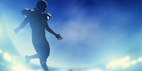 American,football,player,kicking,the,ball,,kickoff.,night,stadium,lights