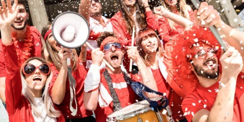 Young,football,supporter,fans,cheering,with,flag,and,confetti,watching