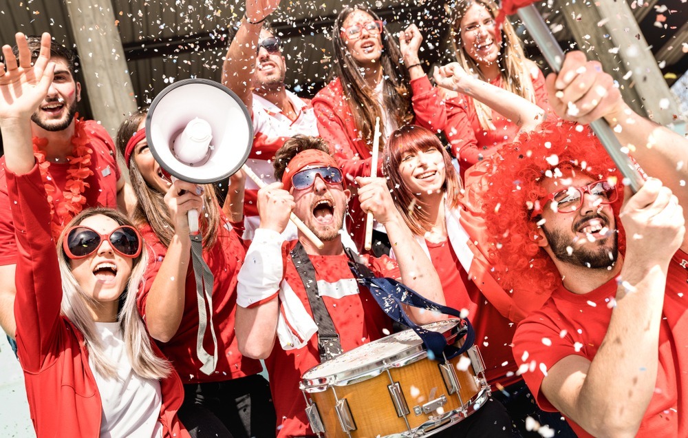 Young,football,supporter,fans,cheering,with,flag,and,confetti,watching