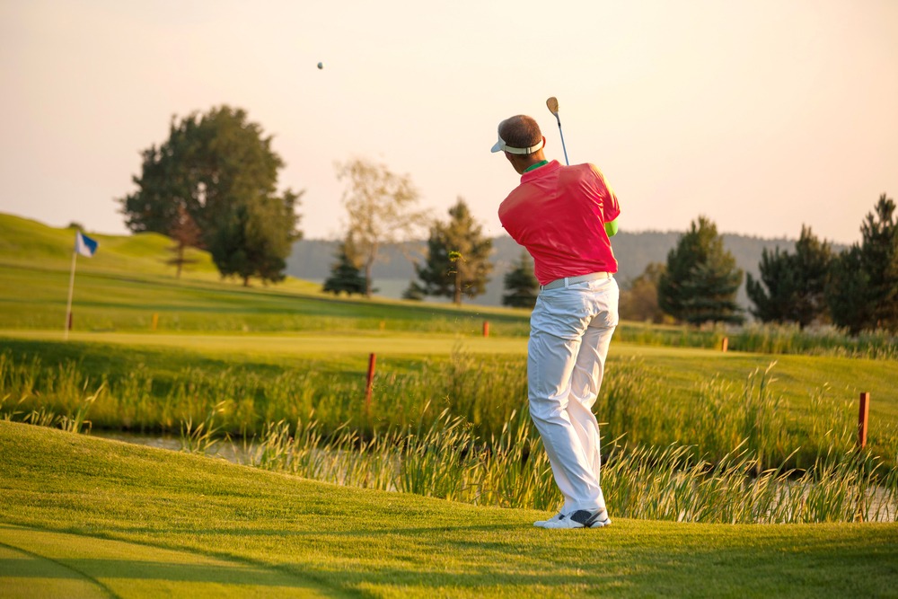 Man,playing,golf,against,sunset